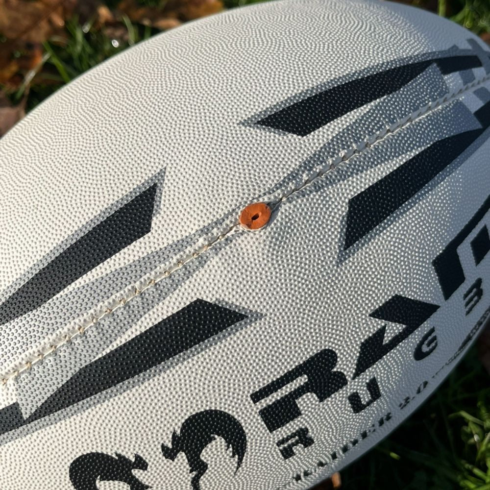Close-up of Ram Rugby Raider 2.0 durable rugby match ball with textured rubber surface and valve-in-seam design for training and games
