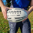 Close-up of Ram Rugby Raider 2.0 durable match ball showing textured rubber laminate and valve-in-seam design for play