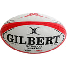 Stack of 30 Gilbert G-TR4000 trainer rugby balls beside two black breathable ball bags for size 5 ball storage and transport